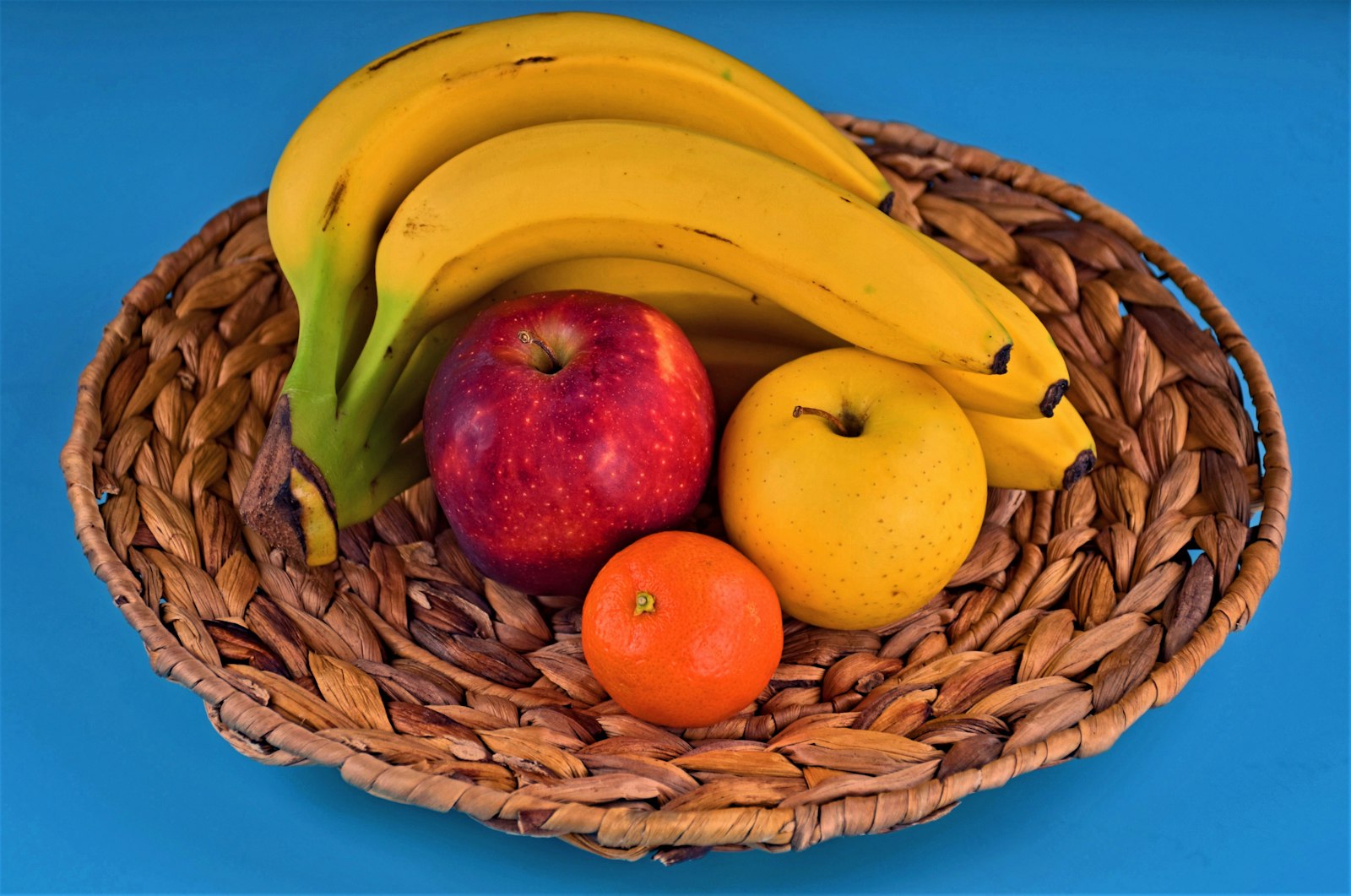 Una canasta de mimbre llena de frutas variadas
