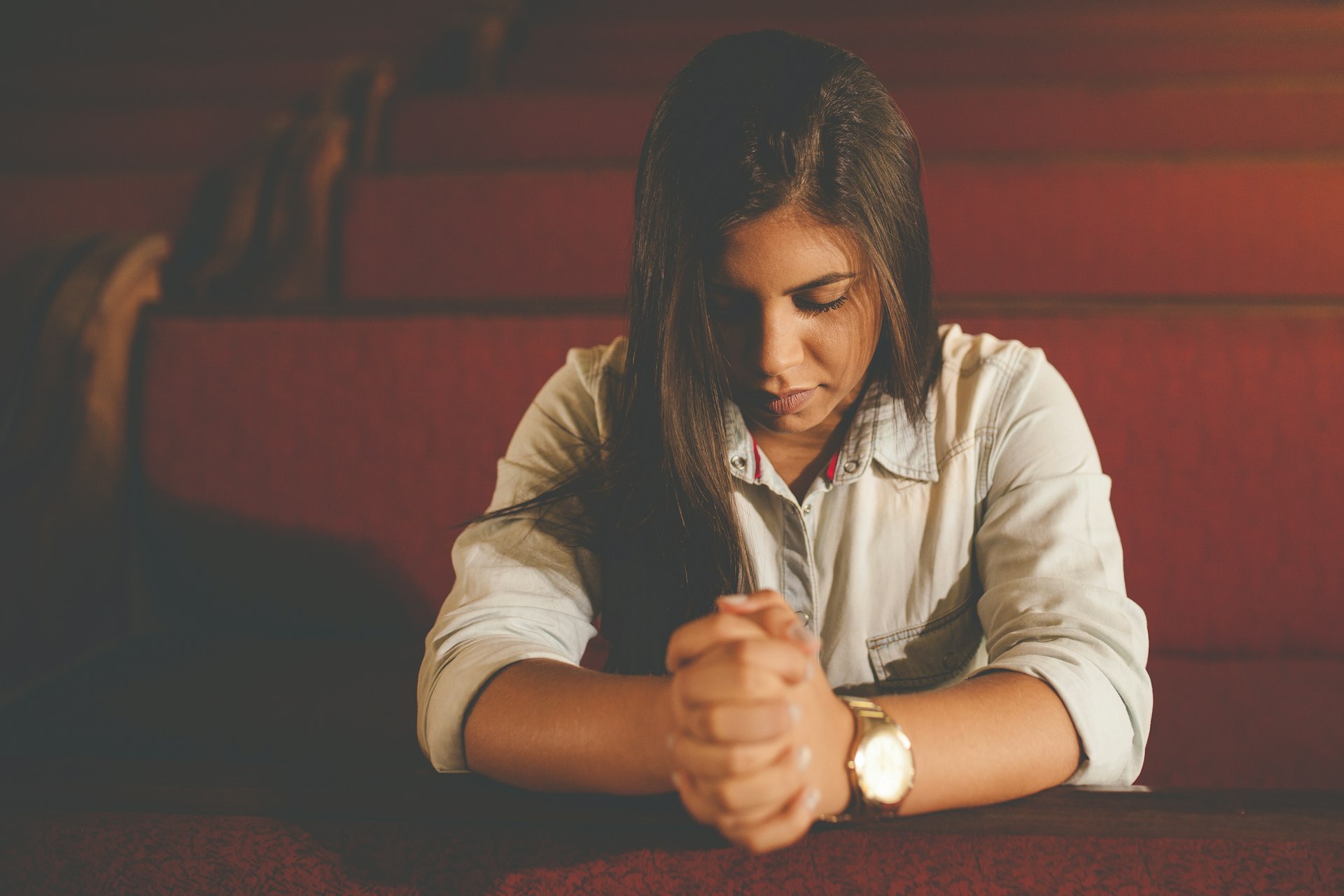 Una mujer orando dentro de una iglesia